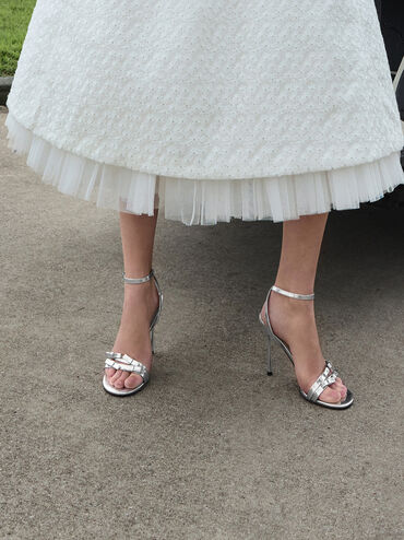 صندل جيسي من الجلد بكعب ستيليتو وحزام حول الكاحل ومظهر معدني مزين بفيونكة, فضي, hi-res