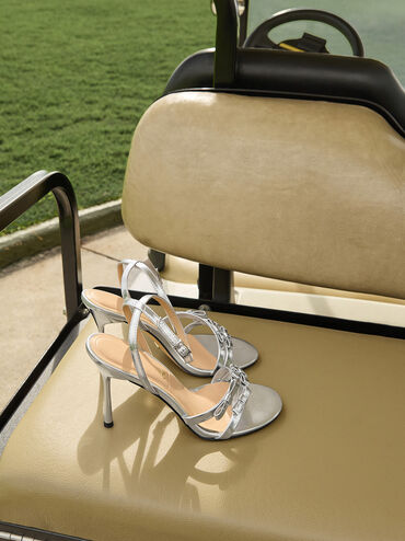 صندل جيسي من الجلد بكعب ستيليتو وحزام حول الكاحل ومظهر معدني مزين بفيونكة, فضي, hi-res