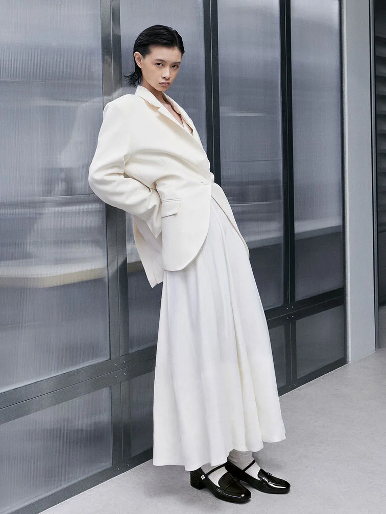 Patent Mary Janes paired with socks, a blazer and a skirt.