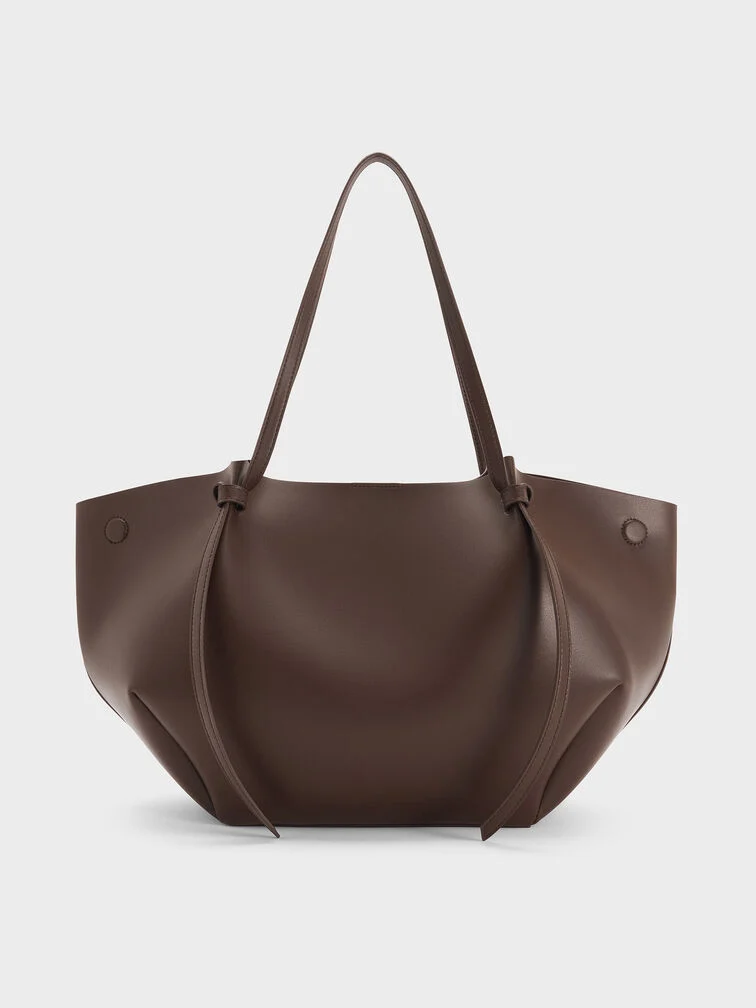 The XL Calla tote bag in espresso brown with the side magnetic clasps folded out creates a wider and slouchier shape 